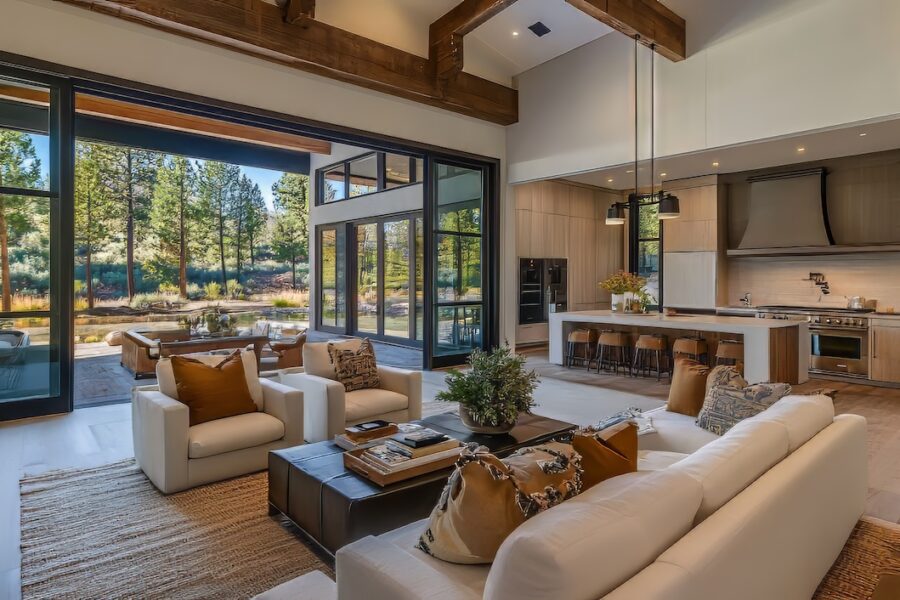 Light-filled California Casual living room with exposed wood beams, neutral sofas, layered textures, built-in shelving, and a warm, relaxed coastal feel