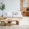 Cozy neutral living room with white sofa, wood coffee table, plants, and layered decor creating a warm, finished interior