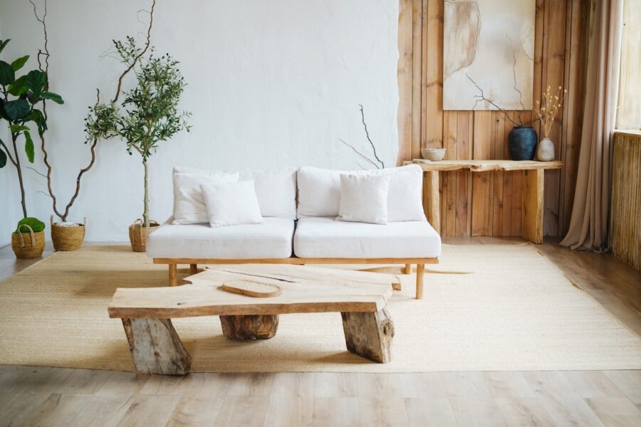 Cozy neutral living room with white sofa, wood coffee table, plants, and layered decor creating a warm, finished interior