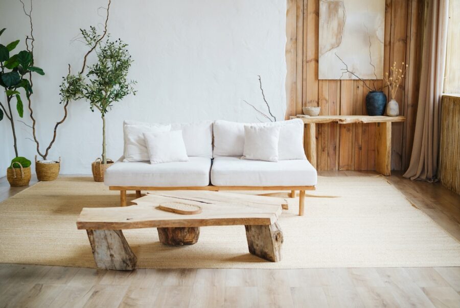 Cozy neutral living room with white sofa, wood coffee table, plants, and layered decor creating a warm, finished interior