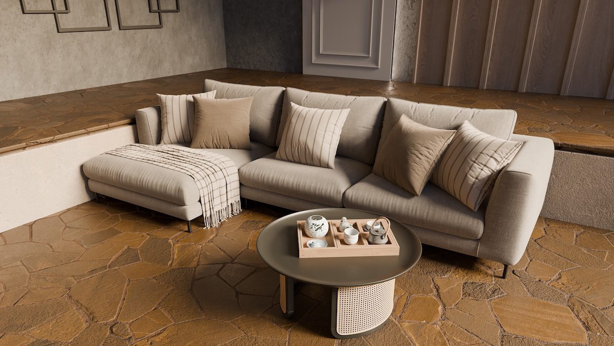 Neutral living room with sectional sofa, layered textured pillows, stone flooring, and natural light creating depth in a minimalist interior