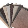 Collection of neutral-toned upholstery fabric swatches displaying various textures, weaves, and performance fabric finishes in shades of beige, gray, taupe, and brown.