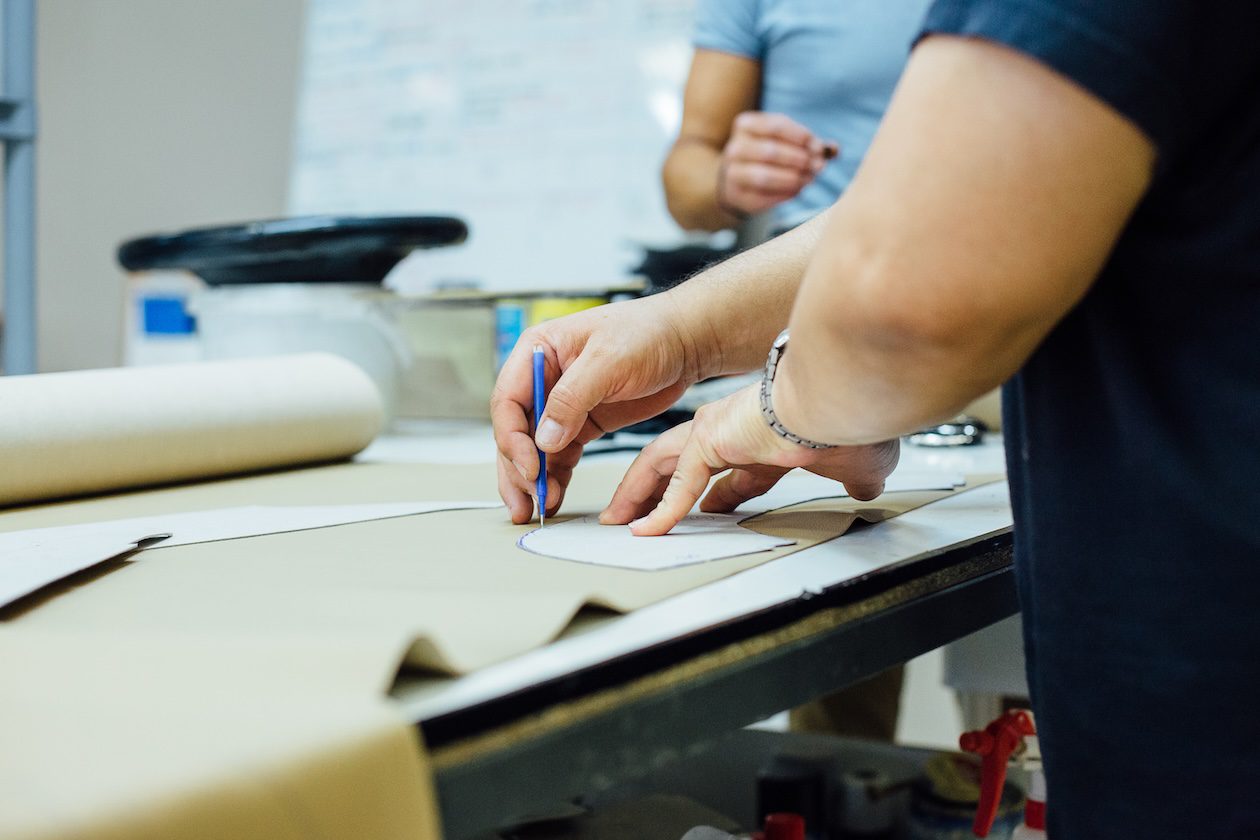 Designer selecting and working with leather upholstery materials for custom furniture and interior design projects.