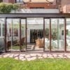 Contemporary home with expansive sliding glass doors creating a seamless indoor-outdoor living space, connecting a bright living room and dining area to a private patio and garden.