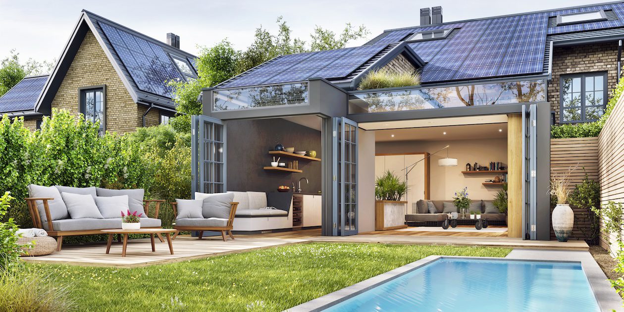 Modern open-concept home with folding glass doors connecting the living room to an outdoor patio, pool, and lounge area, creating seamless indoor-outdoor living.