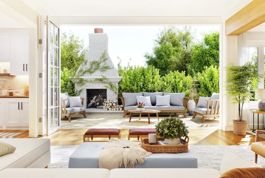 Open-concept California casual living room with large doors opening to an outdoor patio, featuring neutral furnishings, natural wood accents, and seamless indoor-outdoor living.