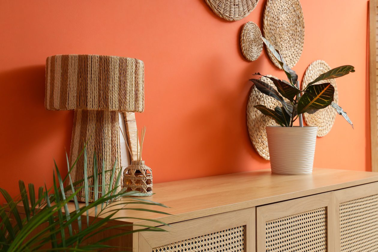 Cane-front wood cabinet with woven lighting and natural fiber accents in a warm interior.