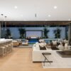 Modern coastal living room with white sofas, warm wood accents, and layered neutral textures