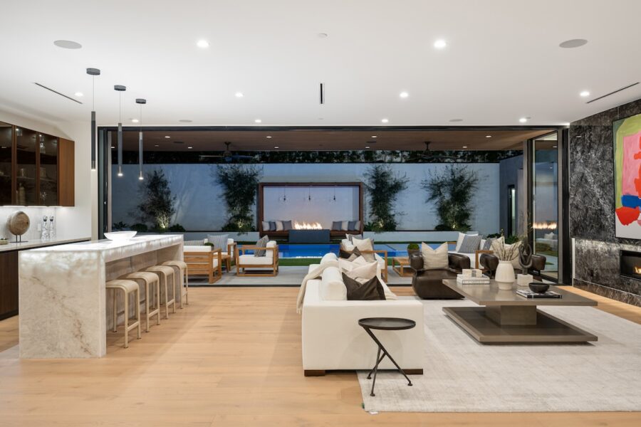 Modern coastal living room with white sofas, warm wood accents, and layered neutral textures