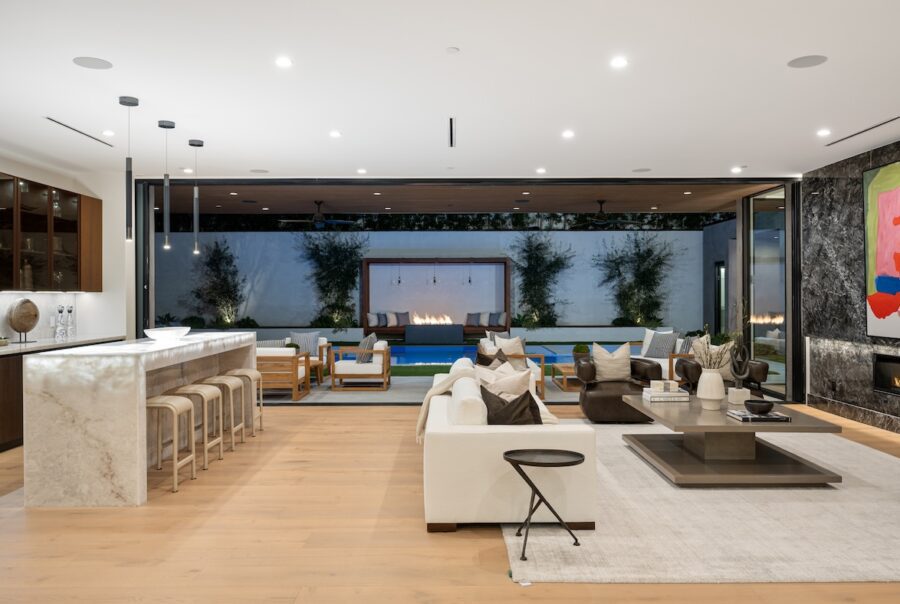 Modern coastal living room with white sofas, warm wood accents, and layered neutral textures