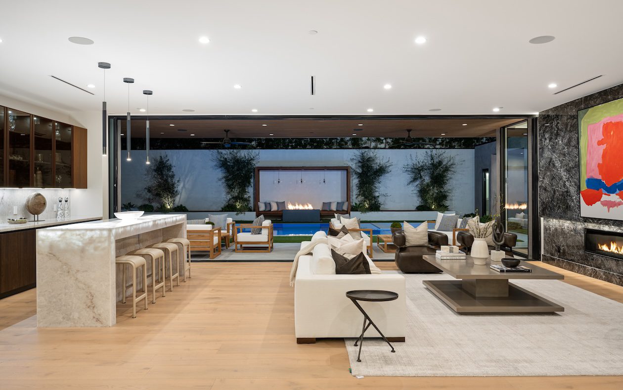 Modern coastal living room with white sofas, warm wood accents, and layered neutral textures